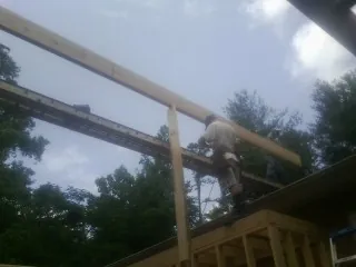 Carpenter setting a ridge beam over a new addition frame — Ice Dam Removal by Roofing Brothers in Springer