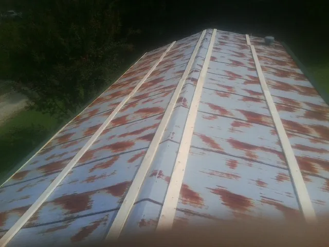 Rusted metal roof panels with new wood purlins before replacement — Storm Damage Roof Repair in Springer by Roofing Brothers