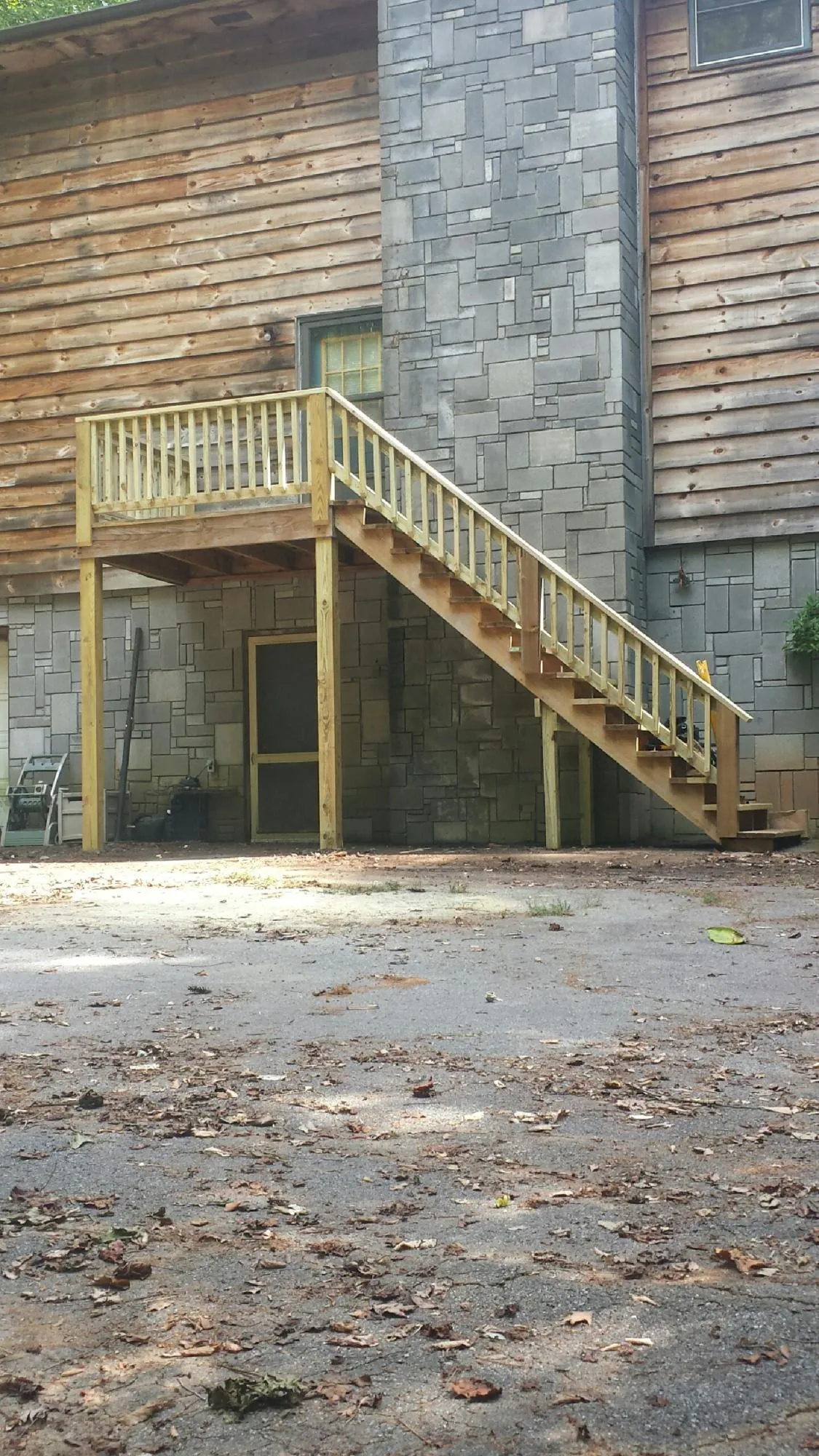 New pressure treated deck and stair landing on a log home in Springer