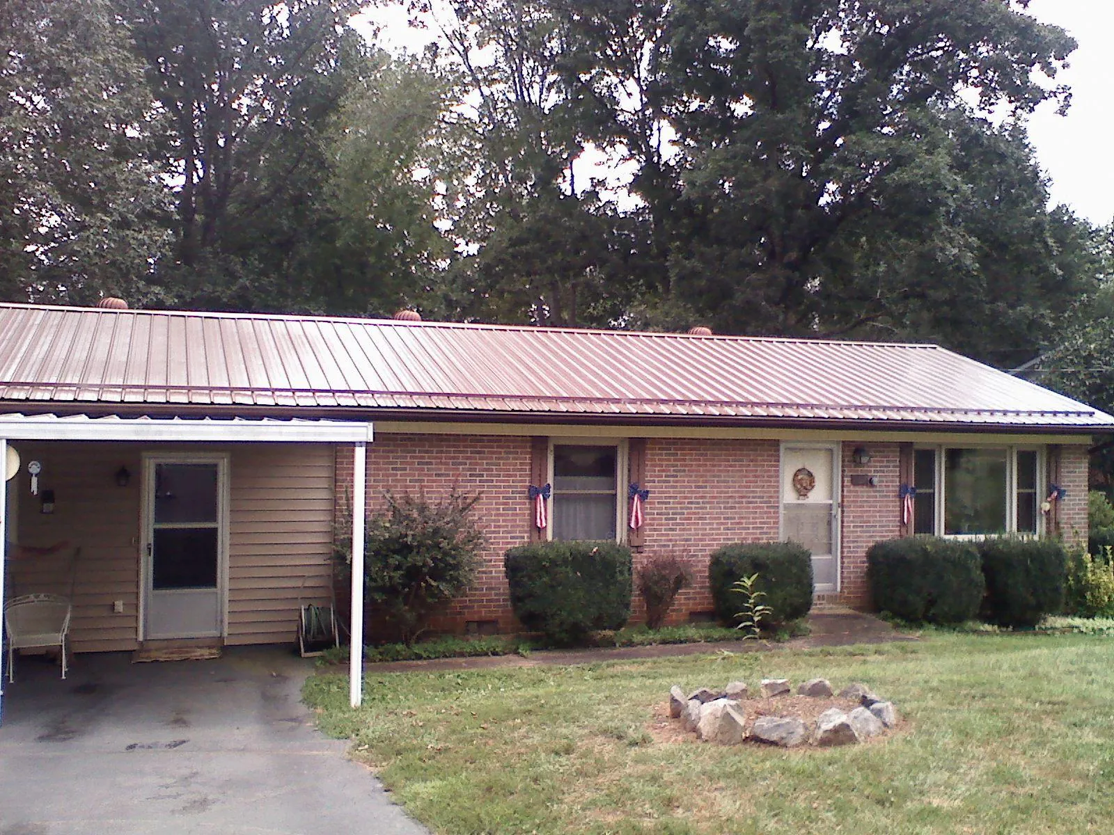 Bronze metal roof and carport on a brick ranch home — Roof Repair work by our crew in Springer
